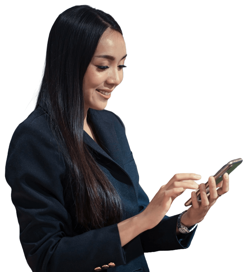 A woman in a dark blazer is smiling while using a smartphone, facing slightly to the left, against a plain light background.