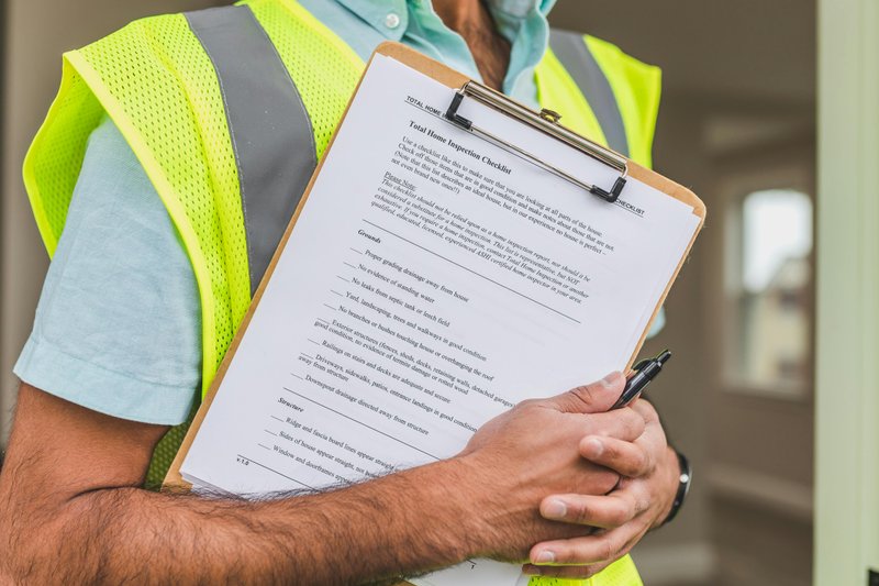 Inspector reviewing compliance checklist on clipboard for gap assessment
