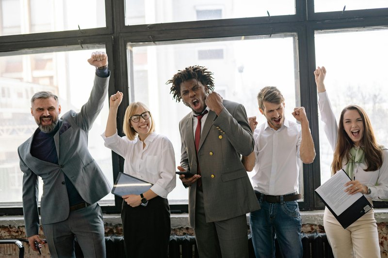 Diverse team celebrating business success and recovery achievement